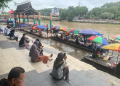 Hujan Deras Dinihari, Pejuang Pasar Terapung Banjarmasin Inipun Tidur di Bawah Payung