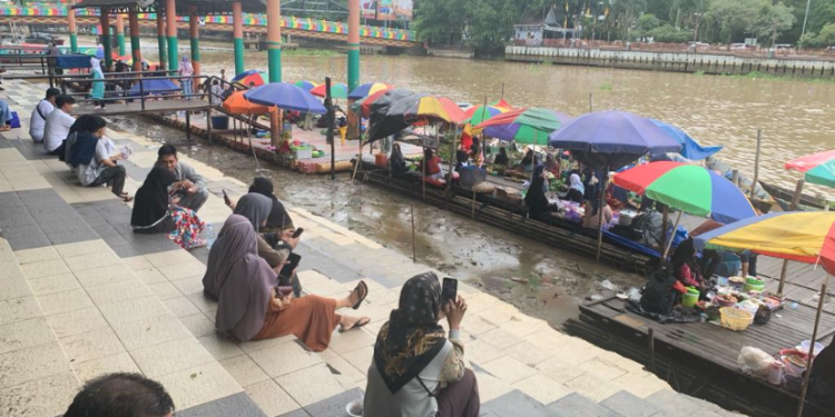 Hujan Deras Dinihari, Pejuang Pasar Terapung Banjarmasin Inipun Tidur di Bawah Payung